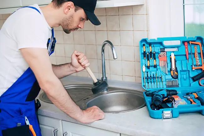 Profissional desentupindo uma pia de cozinha